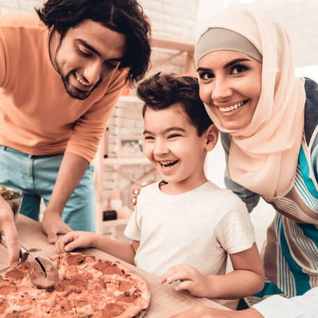 arabic happy family, husband cutting pizza